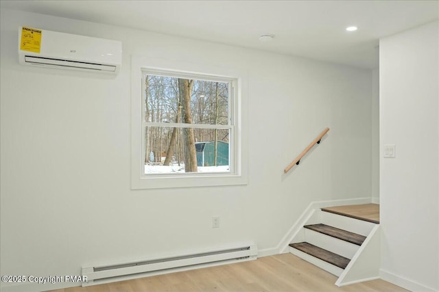 stairs with hardwood / wood-style flooring, an AC wall unit, and a baseboard heating unit