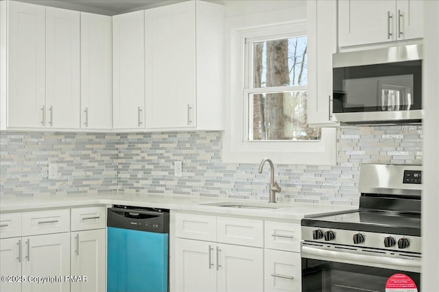 kitchen featuring tasteful backsplash, sink, stainless steel appliances, and white cabinets