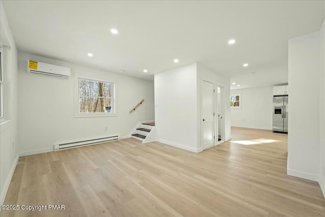 unfurnished living room with a baseboard radiator, an AC wall unit, and light hardwood / wood-style floors