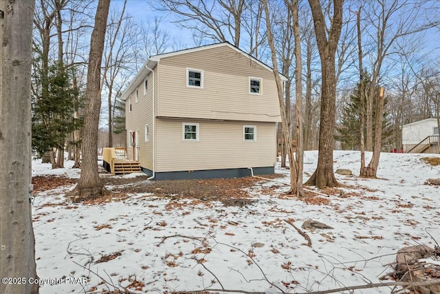 snow covered house with a deck