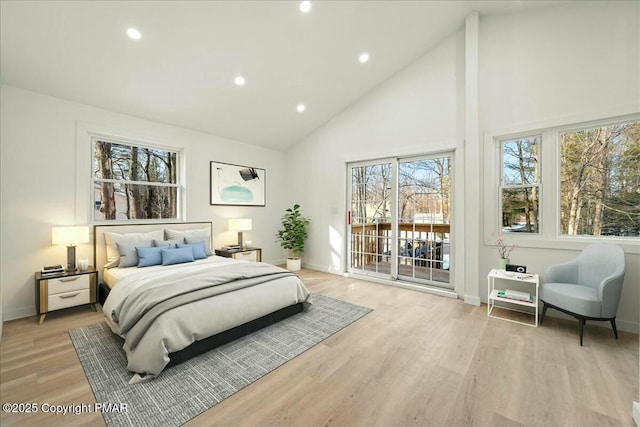 bedroom with high vaulted ceiling, light hardwood / wood-style floors, and access to outside