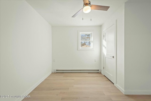 spare room featuring a baseboard radiator, ceiling fan, and light wood-type flooring