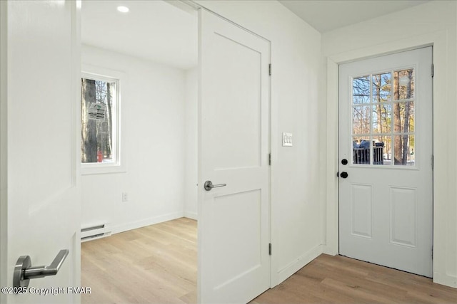 doorway with light hardwood / wood-style floors and baseboard heating