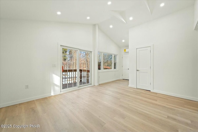 unfurnished living room featuring high vaulted ceiling and light hardwood / wood-style floors