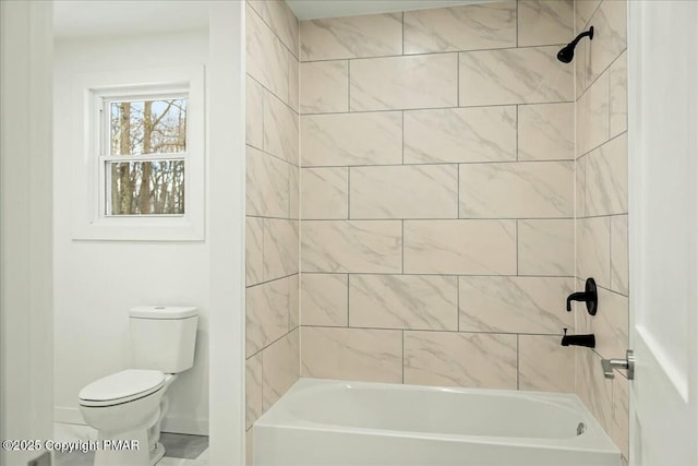 bathroom with tiled shower / bath combo and toilet