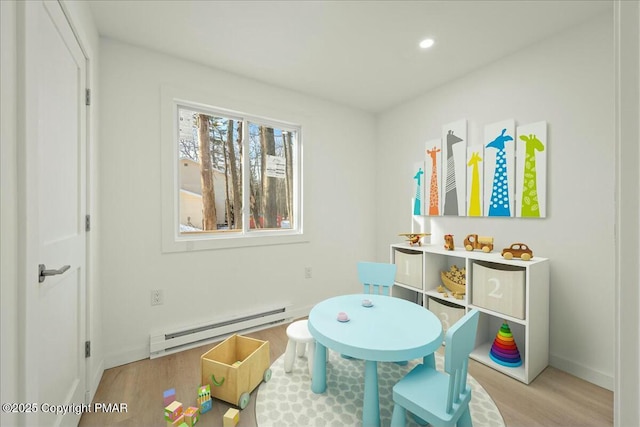 recreation room featuring a baseboard radiator and light wood-type flooring