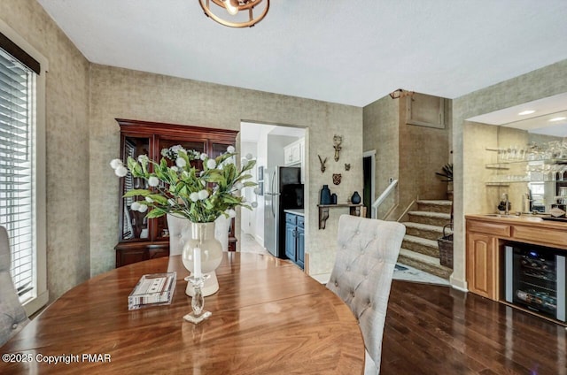 dining area with dark wood-type flooring, beverage cooler, and indoor wet bar