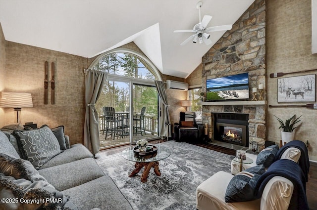 living room featuring high vaulted ceiling, an AC wall unit, ceiling fan, a fireplace, and hardwood / wood-style floors