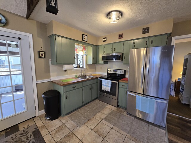 176 Fawn Rd, Pocono Lake, PA 18347 - kitchen with a wealth of natural light, green cabinets, stainless steel appliances, and a sink