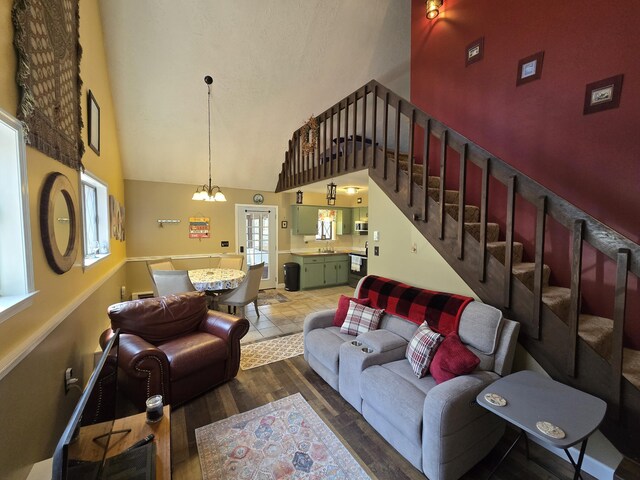 176 Fawn Rd, Pocono Lake, PA 18347 - living area with a notable chandelier, wood finished floors, high vaulted ceiling, and stairs