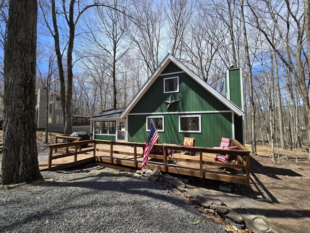 176 Fawn Rd, Pocono Lake, PA 18347 - view of front facade with a chimney, a sunroom, and a deck