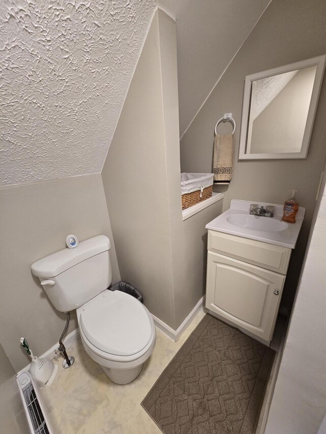 176 Fawn Rd, Pocono Lake, PA 18347 - half bathroom featuring a textured ceiling, toilet, vaulted ceiling, baseboards, and vanity
