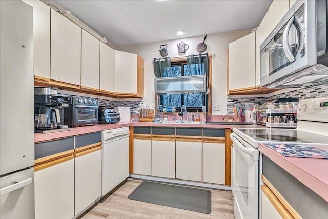 232 Image Dr, Scotrun, PA 18355 - kitchen with white appliances, decorative backsplash, a sink, and light wood finished floors