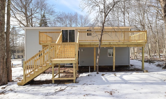 snow covered property featuring stairs and a deck