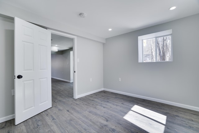 spare room with recessed lighting, wood finished floors, and baseboards