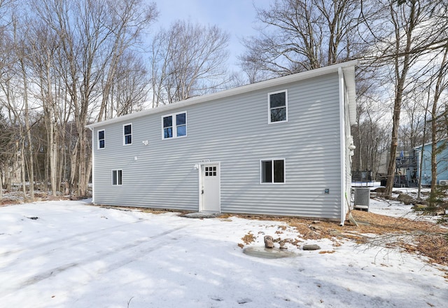 snow covered house with central air condition unit