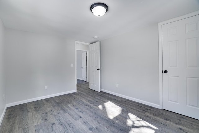 unfurnished bedroom with baseboards and wood finished floors