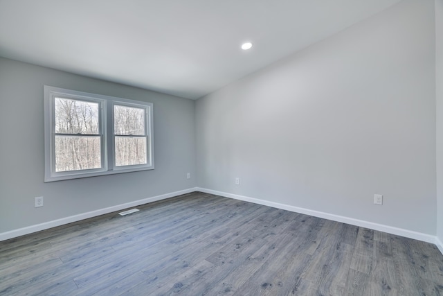 unfurnished room featuring dark wood finished floors, visible vents, recessed lighting, and baseboards