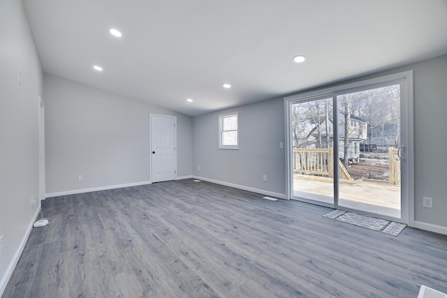 unfurnished living room featuring recessed lighting, baseboards, lofted ceiling, and wood finished floors