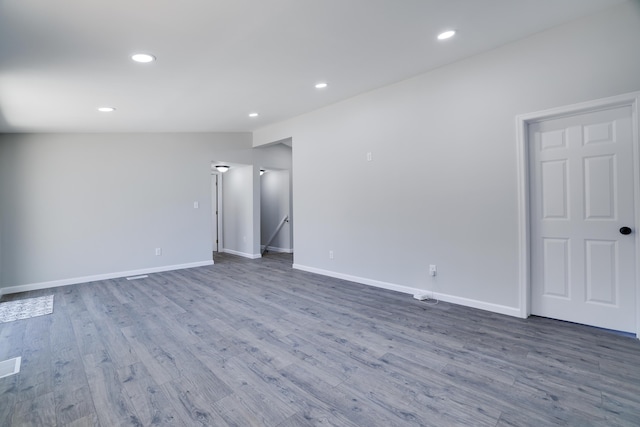 interior space with lofted ceiling, recessed lighting, wood finished floors, and baseboards