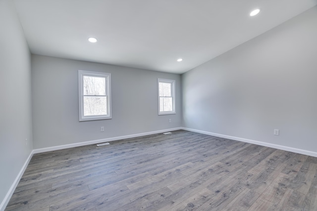 unfurnished room with recessed lighting, wood finished floors, and baseboards