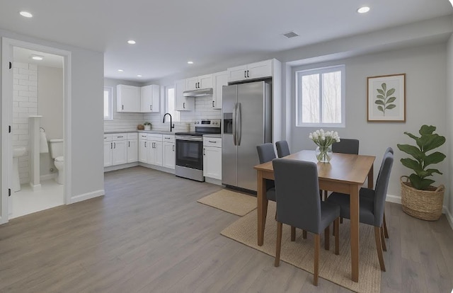 8263 Natures Dr, Tobyhanna, PA 18466 - kitchen featuring stainless steel appliances, white cabinetry, light wood finished floors, baseboards, and backsplash