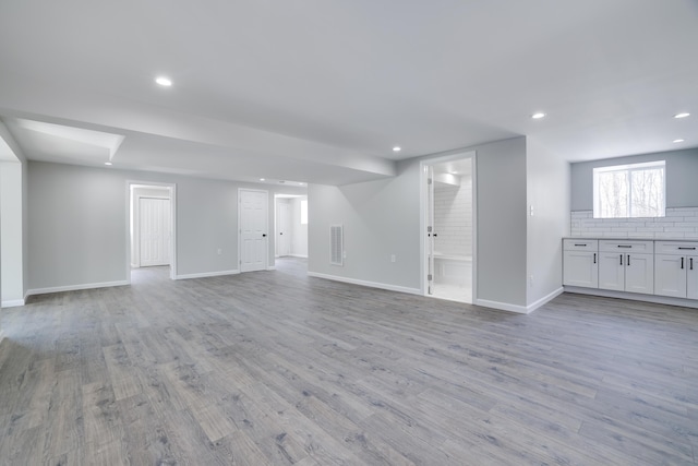 unfurnished living room featuring visible vents, recessed lighting, light wood-style floors, and baseboards