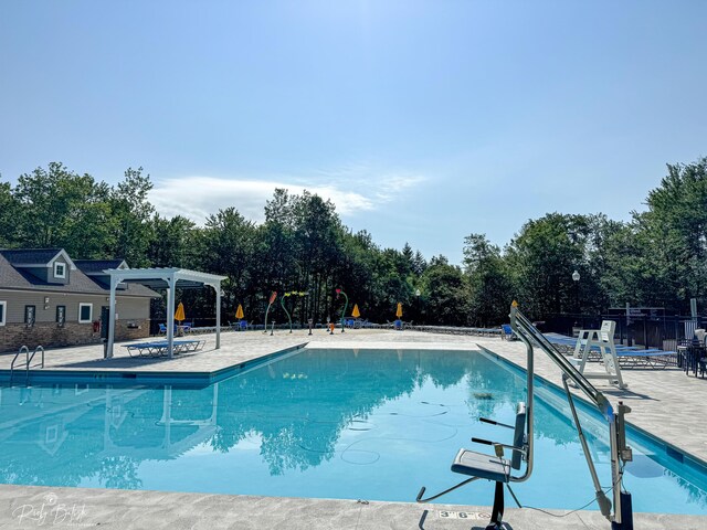 pool with fence, a pergola, and a patio