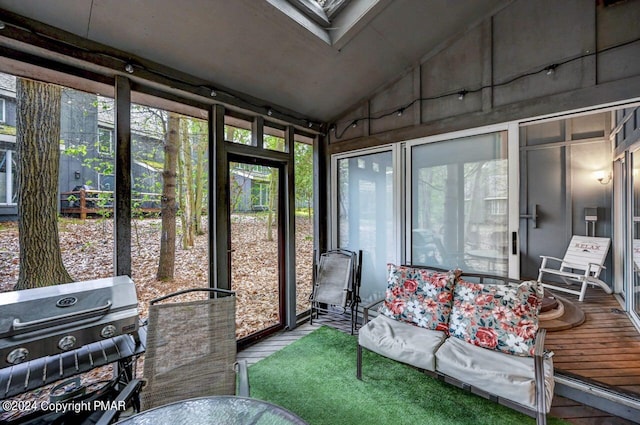 sunroom with lofted ceiling with skylight and a wealth of natural light