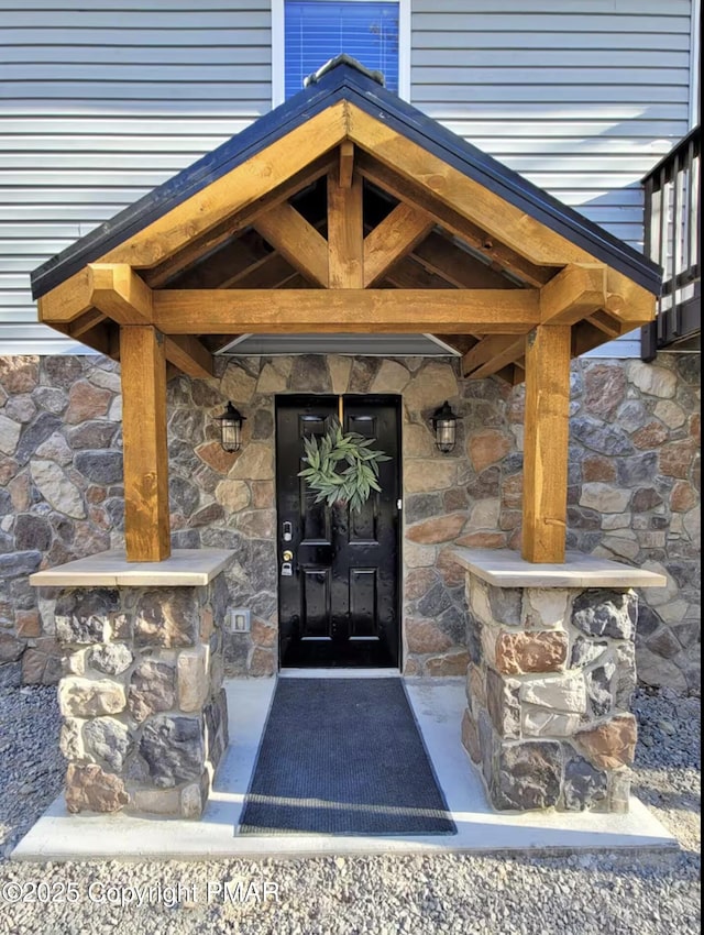 doorway to property with stone siding