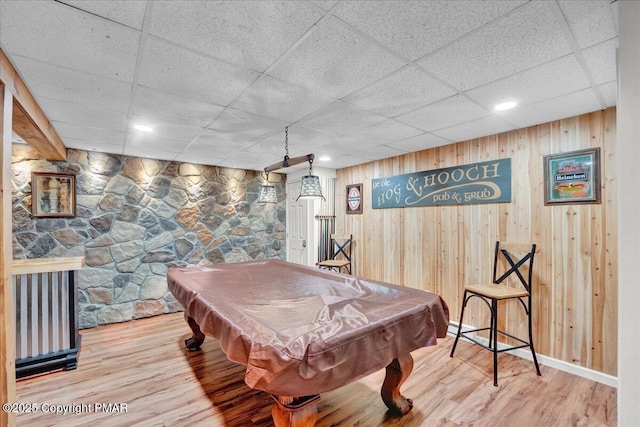 playroom featuring pool table, wood finished floors, wood walls, and a drop ceiling