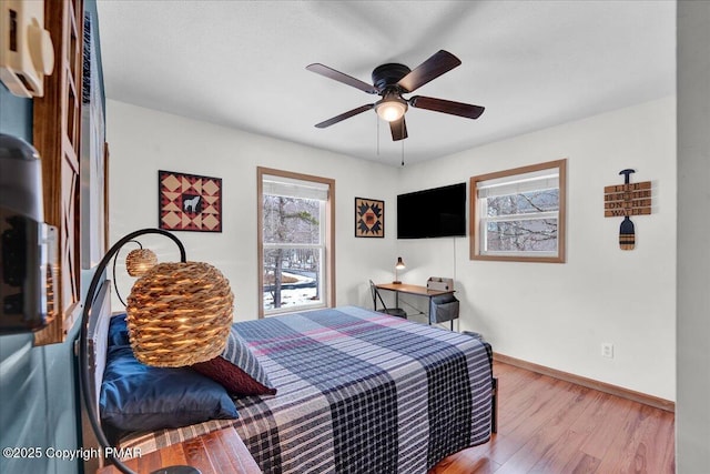 bedroom with a ceiling fan, baseboards, and wood finished floors