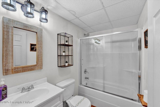 bathroom with vanity, toilet, a paneled ceiling, and bath / shower combo with glass door