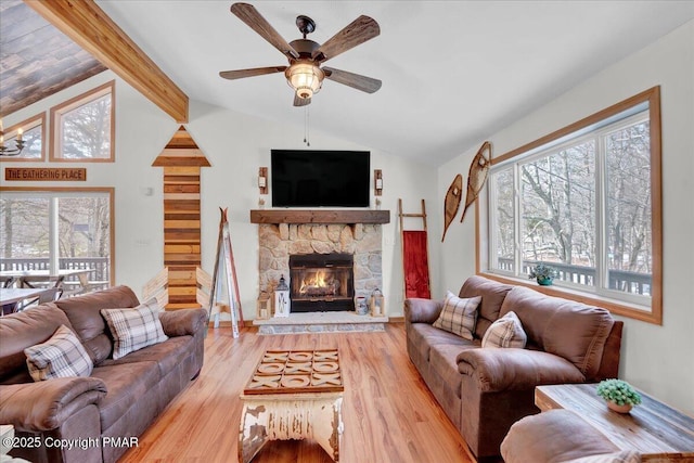 living room with a fireplace, vaulted ceiling with beams, ceiling fan, and wood finished floors