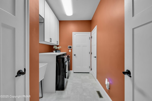 laundry area with cabinet space, baseboards, visible vents, and separate washer and dryer