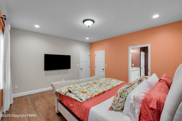 bedroom featuring ensuite bath, baseboards, wood finished floors, and recessed lighting