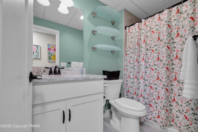 full bath with curtained shower, toilet, vanity, a drop ceiling, and tile patterned floors