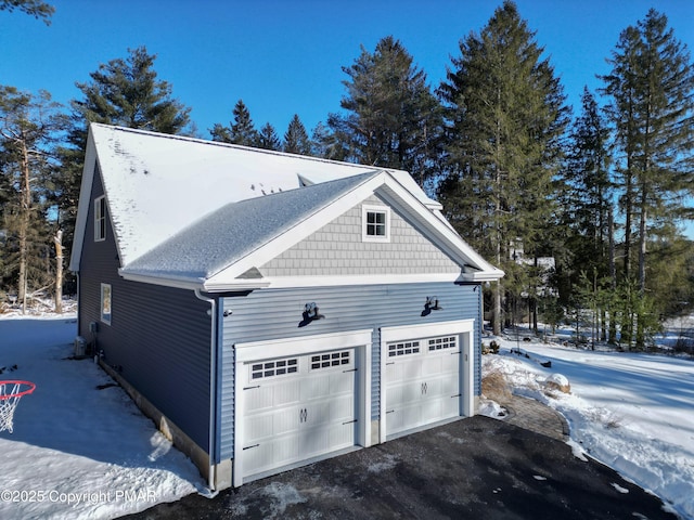 view of snow covered exterior featuring an attached garage