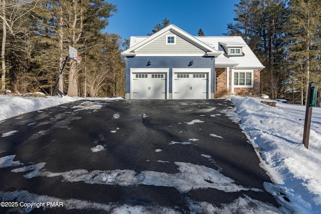 view of front facade featuring a garage, driveway, and stone siding