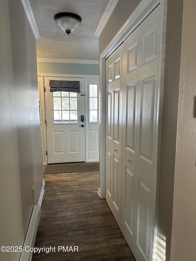 entryway with dark hardwood / wood-style flooring, ornamental molding, and a textured ceiling