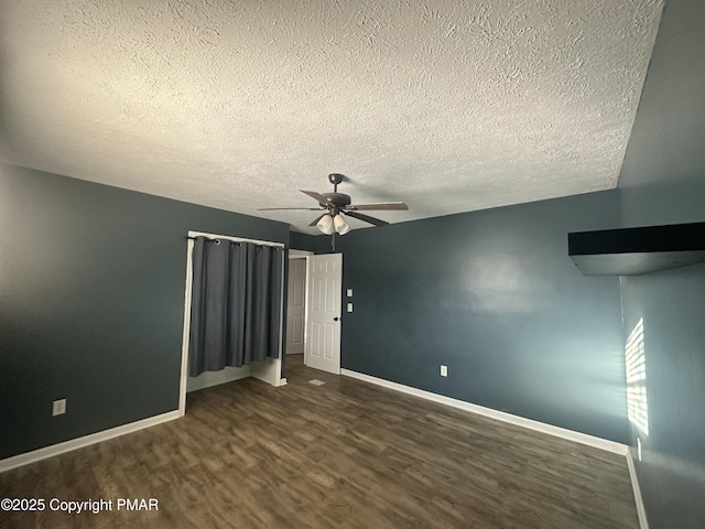 spare room featuring dark hardwood / wood-style floors, a textured ceiling, and ceiling fan