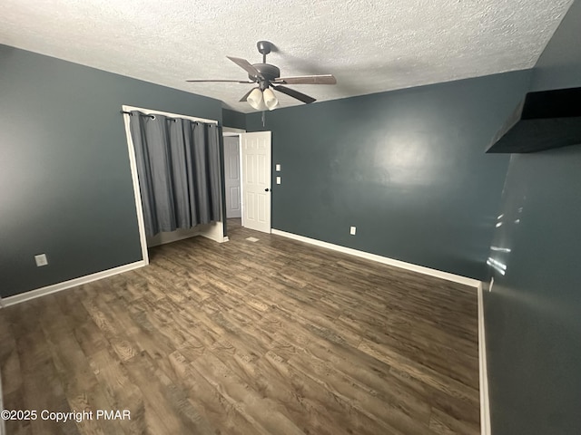 unfurnished bedroom featuring ceiling fan, a textured ceiling, and dark hardwood / wood-style flooring