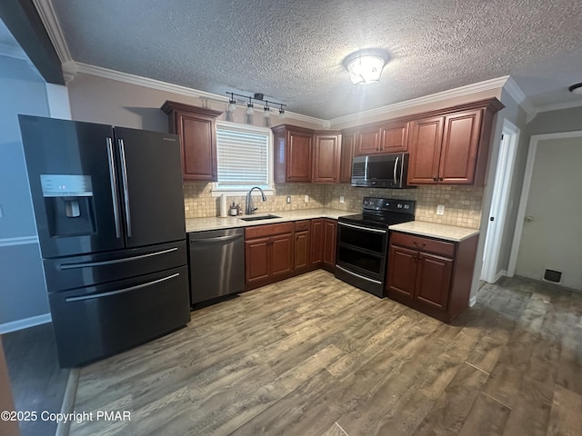 kitchen with sink, wood-type flooring, ornamental molding, decorative backsplash, and black appliances