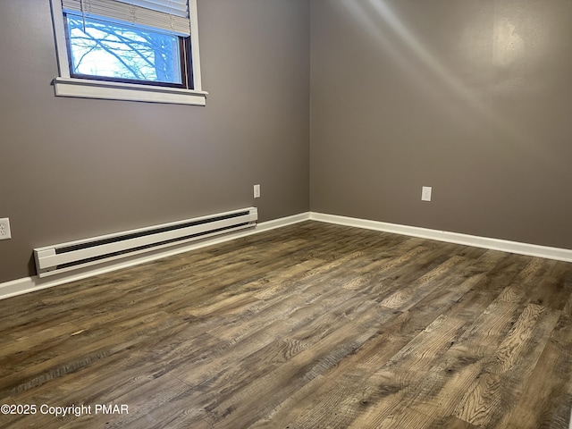 empty room with a baseboard heating unit and dark hardwood / wood-style floors