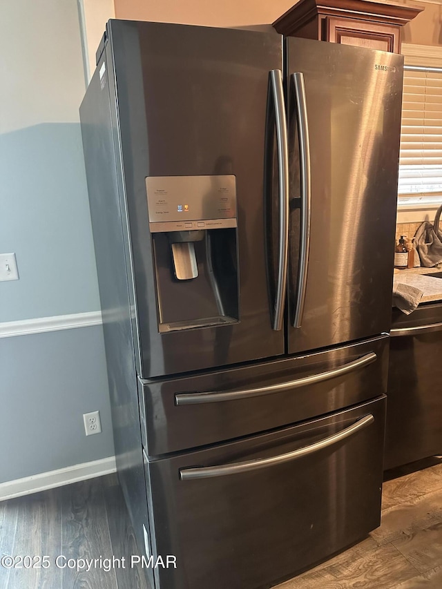 room details with stainless steel fridge and dark hardwood / wood-style flooring