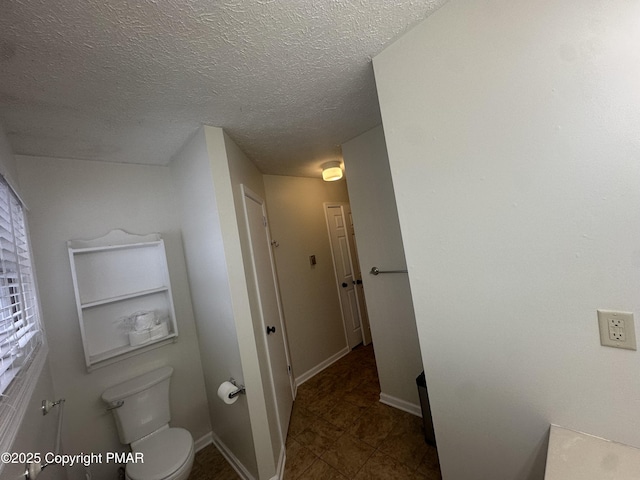 bathroom featuring a textured ceiling and toilet