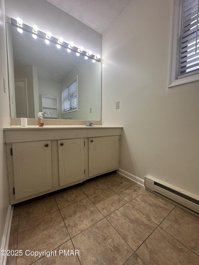 bathroom with vanity, tile patterned floors, a textured ceiling, and baseboard heating