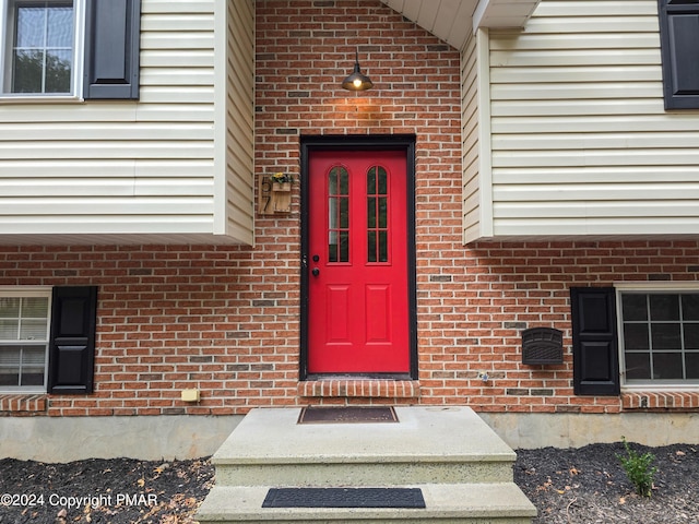 view of exterior entry with brick siding