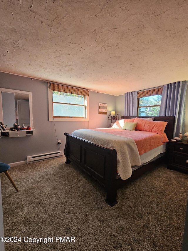 bedroom featuring carpet, multiple windows, baseboard heating, and a textured ceiling