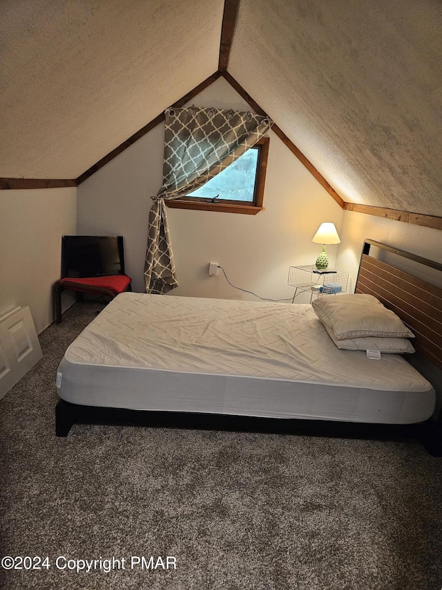 bedroom featuring lofted ceiling, carpet flooring, and a textured ceiling